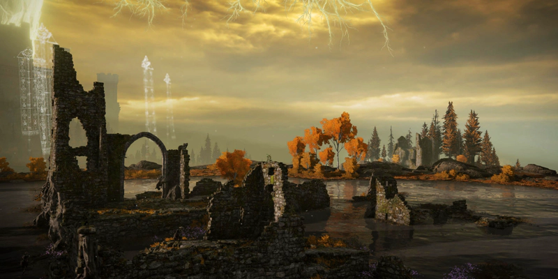 A clump of broken-down stone ruins amidst a shallow lake, decorated with little purple flowers. On the lakeside, the trees are golden, and at the far left, spectral banners rise in the distant sky.