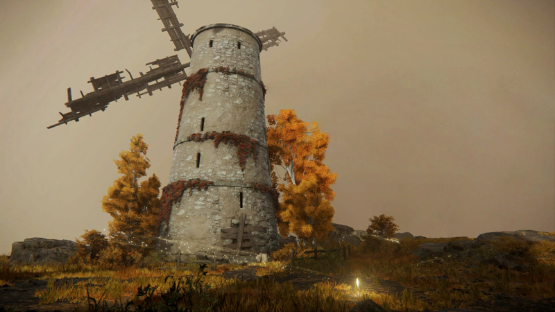 A shining grace in a field at the foot of a large stone windmill. The blades are in disrepair, and the light grey stone is overgrown with red foliage. Tall golden trees grow clustered around the base of the structure, and the sky beyond is cast in shades of grey-pink.