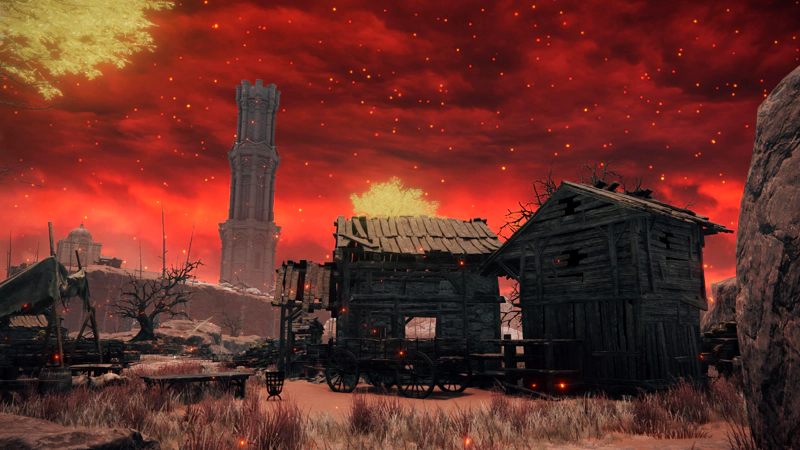 A cluster of dilapidated wooden shacks in a patch of pale pink earth. The sky above is variegated crimson and speckled with embers. Golden foliage rises into the sky from far off erdtrees.