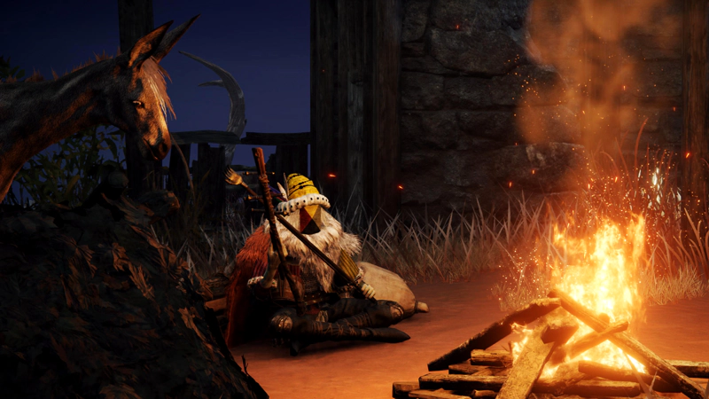 A merchant wearing furs, a yellow hat and a geometric face mask sits at a bright fire in a ruin. A donkey stands in the night, its face lit by firelight.