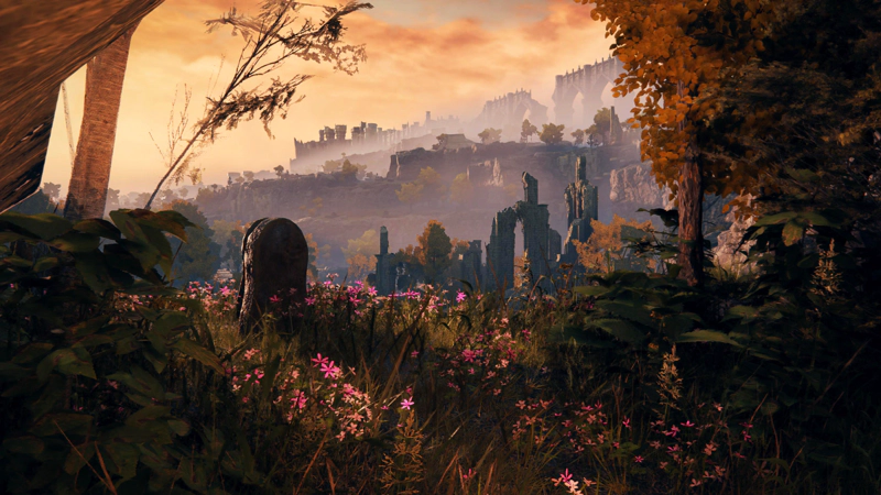 A small graveyard at sunset, speckled with pink flowers. In the distance, tiers of ruin-strewn cliff-sides fade into the distance.