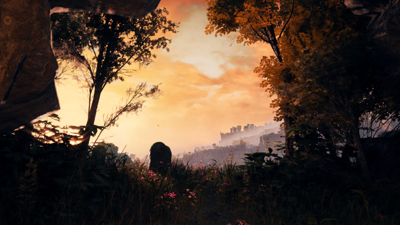 A small graveyard at sunset, speckled with pink flowers. The sky above is gentle orange, and in the distance, castle battlements may be seen.
