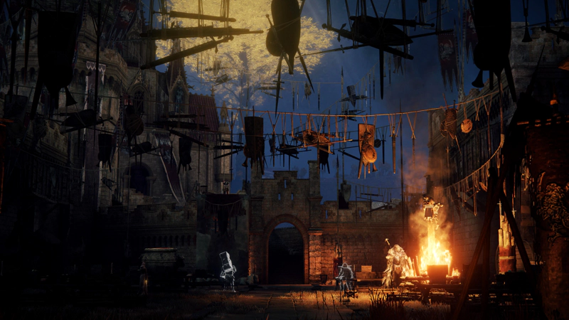 A populated castle courtyard, decorated with overhead ropes heavy with dangling weaponry. Spirits of warriors stand ready for a festival, and a familiar wolf-headed warrior warms himself by a blazing fire. Above, the sky is deep blue against the gold of a minor erdtree.