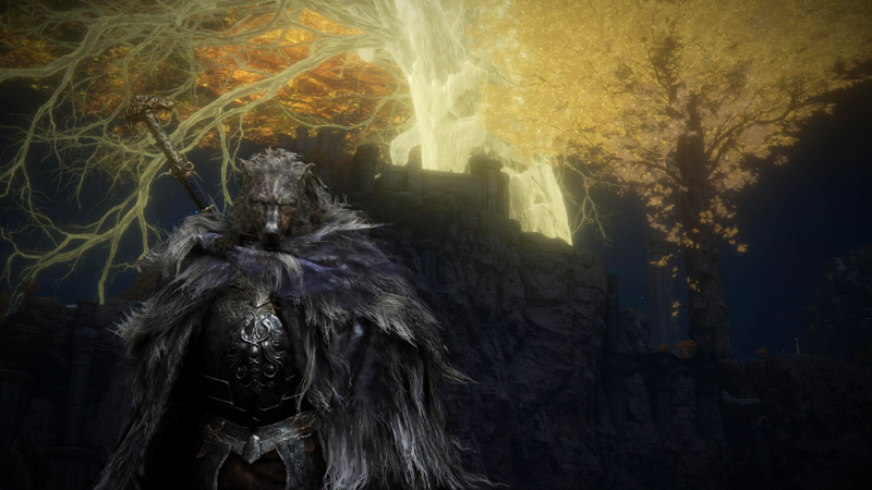 Blaidd, a wolf-headed warrior with a two-handed sword across his back, faces the camera with his back to a tall cliff. Atop the cliff stands a fortress, and towering above the fortress is the golden brilliance of the Erdtree.
