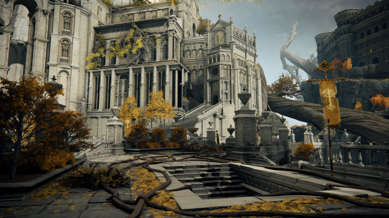 A paved rampart, with a set of stairs descending into the wall, leading towards a large cathedral of pale grey stone. Golden leaves have fallen everywhere, and thin tree roots wend across the floor.