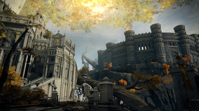 An expansive view beneath the Erdtree's golden branches. To the left, a large cathedral of pale grey stone climbs towards the Erdtree trunk; to the right, a winding cliff-path leads up to a large circular colosseum.