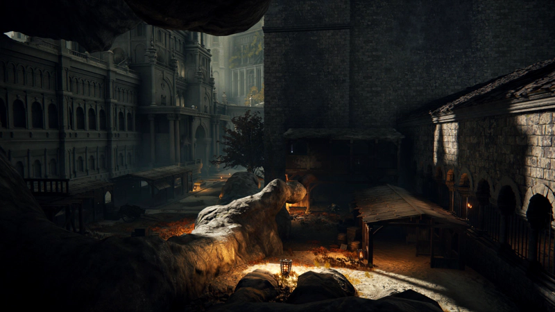 A view down a backstreet of the capital city. To the right, a pair of rough wooden stables stand, and beside those, the sunlight washes across the leg of a vast fallen dragon, long dead.