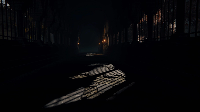 A stone cloister leading into the dark. The arched windows are barred, and the low sun casts the bars as long shadows across the floor.