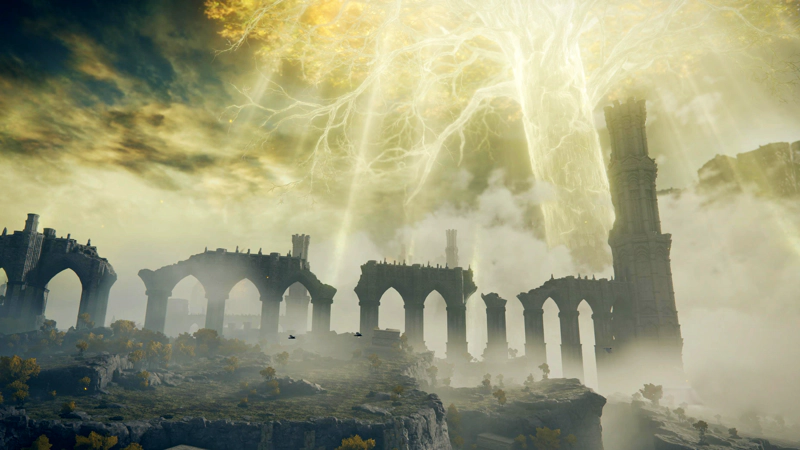 A broken viaduct rises above sunlit cliffs, leading to a tall stone tower. The vast Erdtree shines golden above it all, painting the clouds bright yellow.