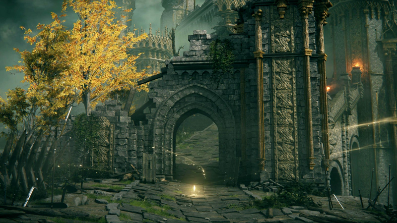 A broken castle gateway. A bright yellow tree stands in place of one of its towers, and a bright shard of grace hovers in the centre of the path.