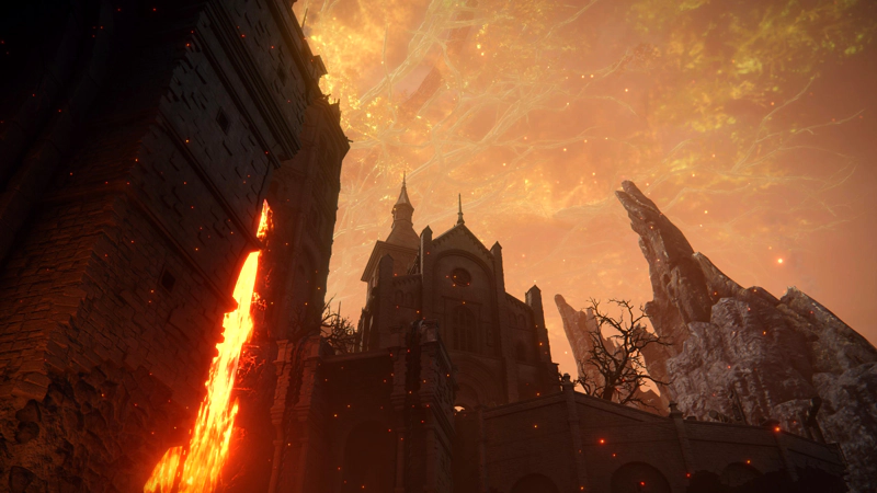 A view from the bottom of the manor, looking upwards past a lava-fall towards a church high above. In the sky, the branches of the Erdtree shine red-gold, lit by the glow of the volcano.