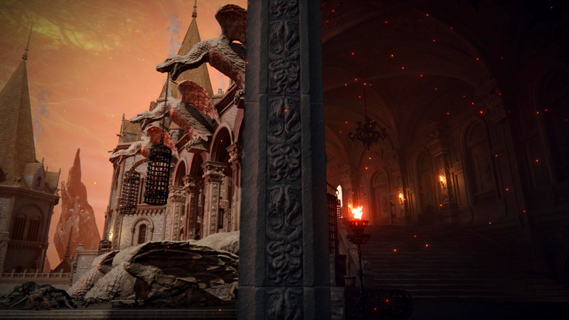To the left of a central pillar, a view of the outside of Volcano Manor, decorated with winged-snake statues carrying black-iron cages, beneath the glowing Erdtree. To the right of a central pillar, a dimly-lit interior, with red flames and black-iron chandeliers.