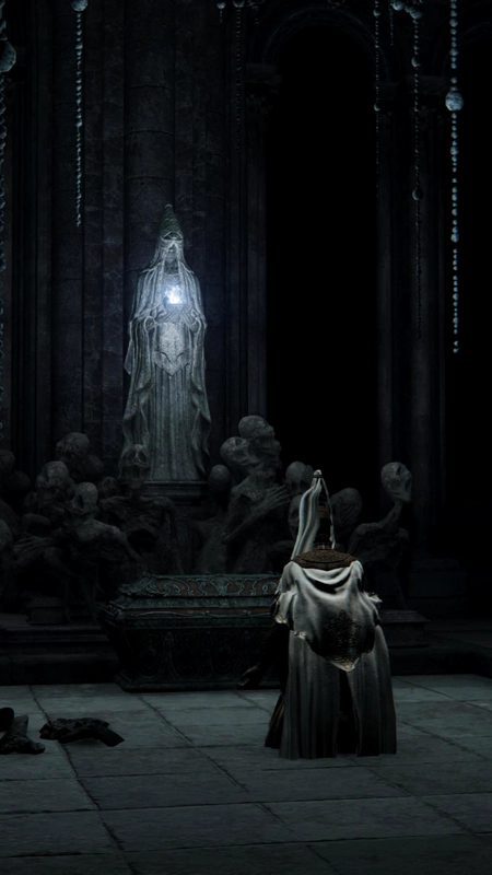 A swordstress in white and gold armour, kneeling in supplication before a robed statue holding a bowl of white fire. The statue is surrounded by a sculpture of screaming corpses, and in front of them is an ornate ark of red and black metal.