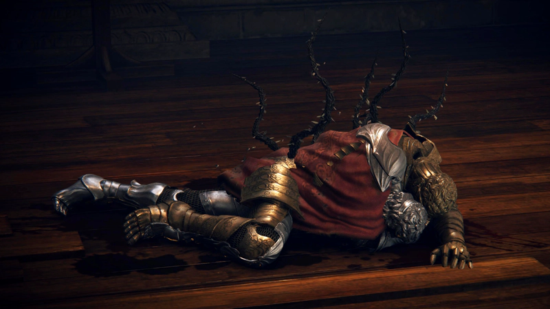 A close-up of D's body, drawing attention to his distinctive twinned gold and silver armour, which has two heads, one of each metal. The vines growing from his back have large pale thorns on them.