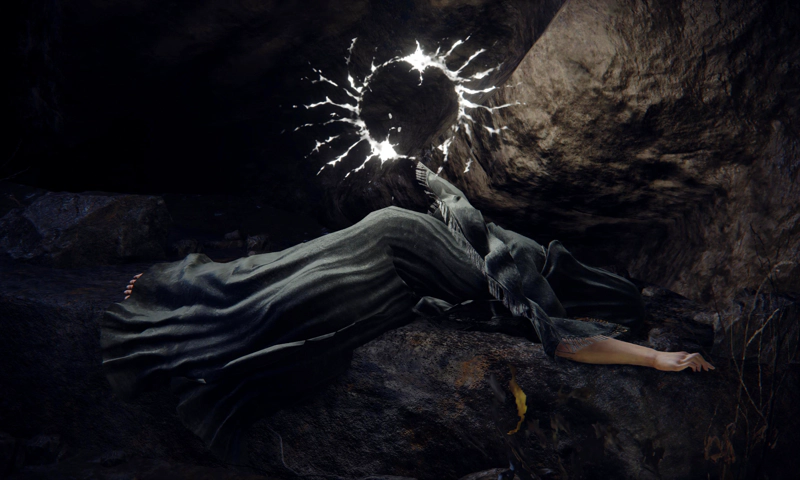 Fia's corpse lying upon a rock, one pale hand extended, her fingers flexed. She has achieved communion with the Prince of Death, and a glowing white rune, circular and spidery, shines from the rock wall behind her.