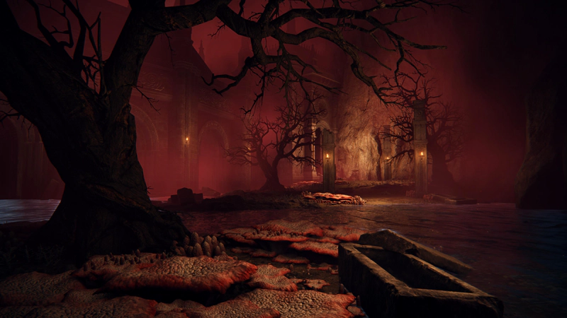 A partially-flooded underground cavern wreathed in crimson mist. Bare-branched trees accompany a red coral path past ruined pillars towards an oblique archway. In the foreground a stone coffin lies empty, its lid askew.